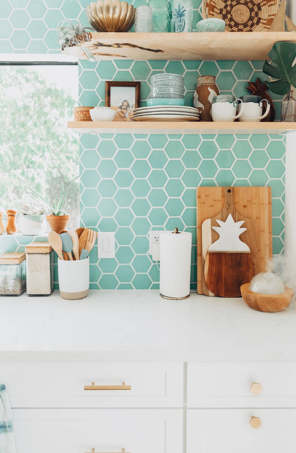 a bright kitchen with a mint green tile backsplash