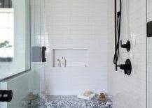 black and white marble tile bench in walk in shower with black faucets white subway tile and mosaic floor tiles glass door