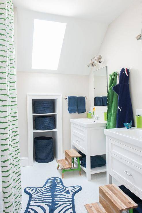 green and blue kids' bathroom with green and white lizard shower curtain, blue zebra print rug and navy blue towels, featuring skylight to allow for natural light