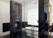 Modern bathroom design features a black marble walk in shower with his and hers shower heads, an antique brass towel warmer and black hexagon floor tiles.