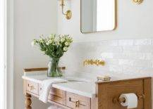 brown wood open bottom bathroom vanity with gold faucet sink toilet paper holder gold frame mirror wall sconces