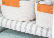 shelf liners on wire shelf with white rope baskets and rolled blue towels