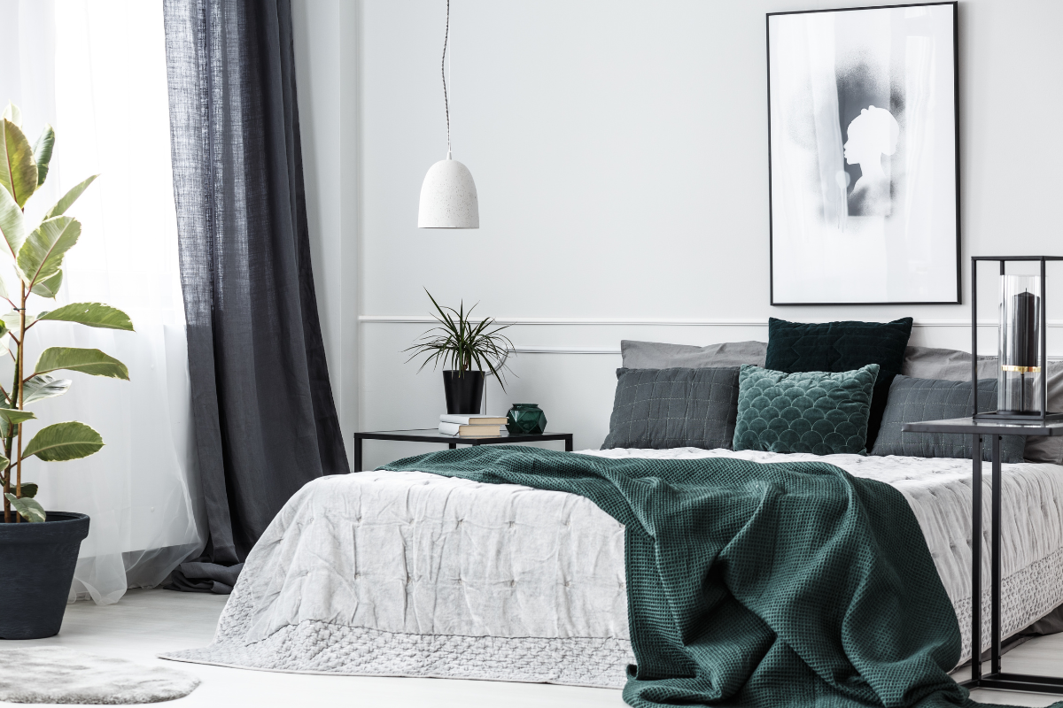 white black and emerald green bedroom with low bed hanging lamp